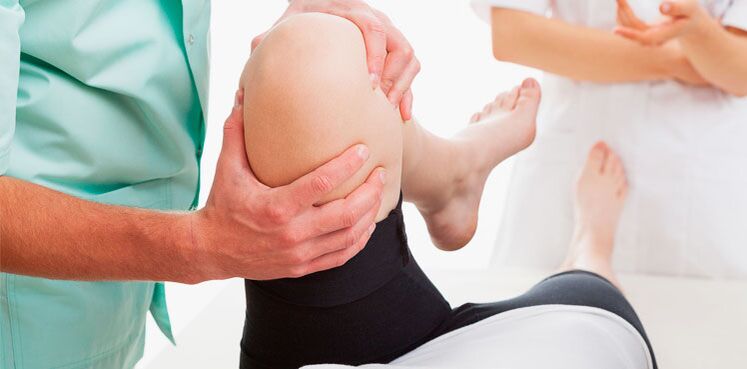 doctor examining knee for pain